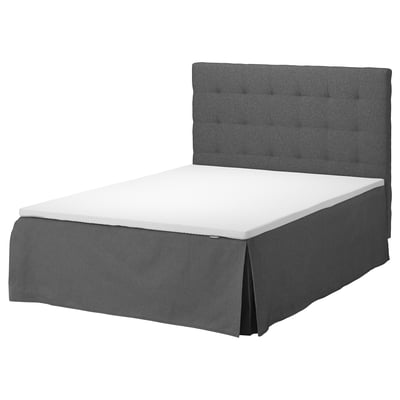 Grey upholstered bed with tufted headboard and white mattress.