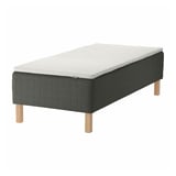 A SKOTTERUD bed in dark grey with wooden legs. It combines a sprung mattress and a foam mattress pad for comfort.