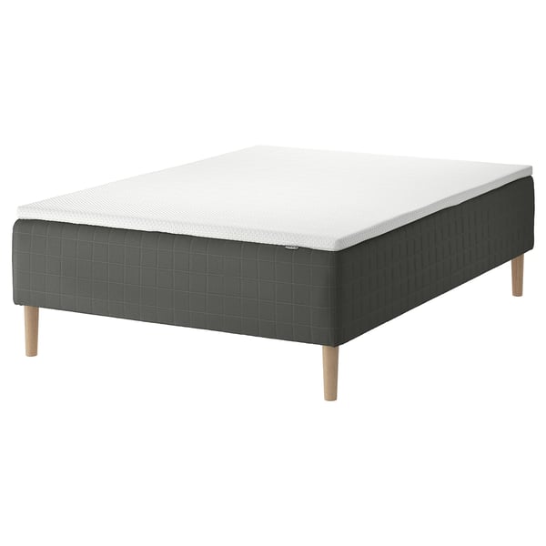 A SKOTTERUD gray mattress on a wooden base with light wood legs. It has a rectangular shape and a textured surface with a white top.