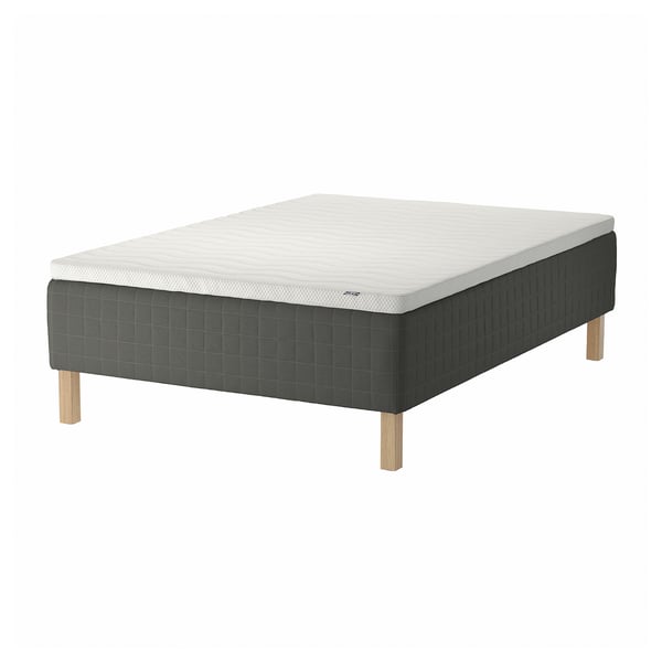 Gray IKEA SKOTTERUD bed with quilted mattress on wooden legs, white top, sturdy base.