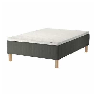 Gray IKEA SKOTTERUD bed with quilted mattress on wooden legs, white top, sturdy base.