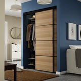 Modern grey bedroom with grey closet, partially open, between mirror & bed.