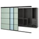 Modern wardrobe with sliding glass doors, dark frames, and internal organizers including shelves and drawers.