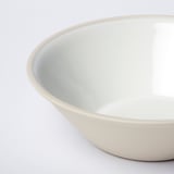 Smooth, handmade stoneware bowl in soft white, set against a white background.