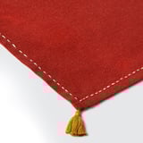 Red woven napkin with hand-stitched edges and yellow tassels, showcasing high-quality craftsmanship.