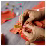 Red tablecloth, yellow fringe, pink nails, tattoo.