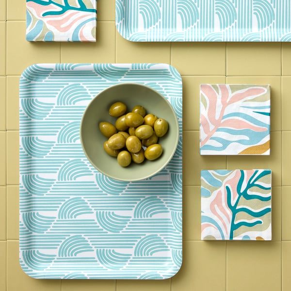 A decorative tray holds a bowl of olives on a colorful backsplash with patterned tiles.