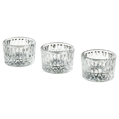 Three clear glass candle holders in varied sizes, featuring intricate cut designs, arranged in a neat row.