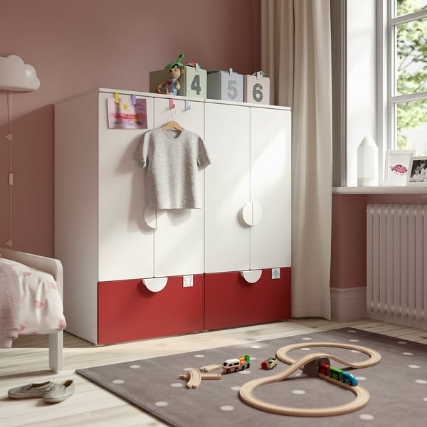 Kids room with red SMÅSTAD wardrobe, shirt, bed, and toy train.