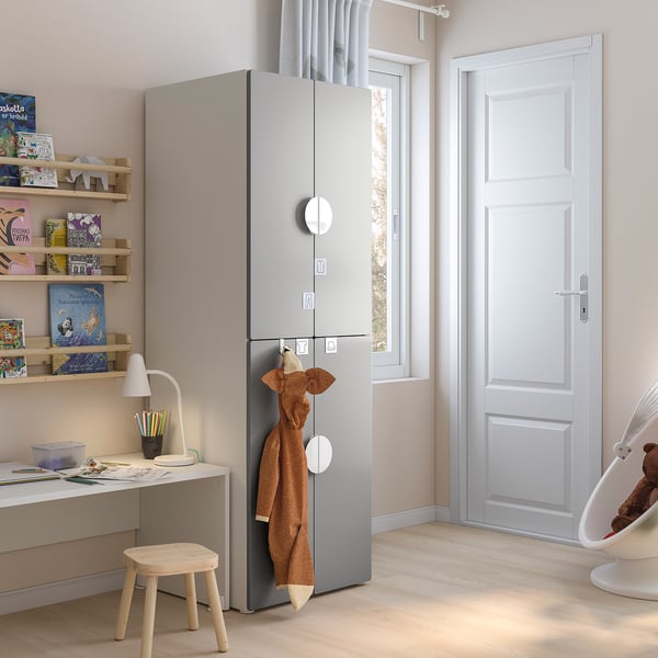Kids gray storage unit with shelves, hanging area, and hooks in a room with a desk and books.