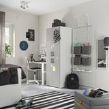 Teen bedroom with gray SMÅSTAD wardrobe, black backpack, striped rug, and desk with chair.