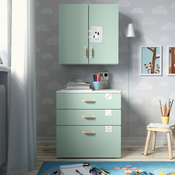 Kids room with green SMÅSTAD cabinet, 3 drawers, 2 doors, soft-closing hinges, and wall-mounted, featuring a stool and artwork.
