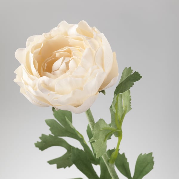 Artificial white flower with green leaves. Crafted from recycled materials, looks realistic.