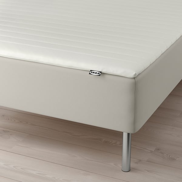 White bed on legs, ikea tag visible.