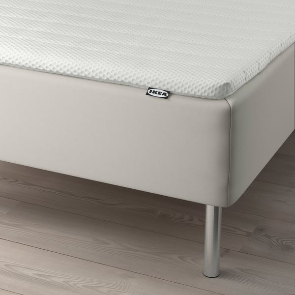 Ikea bed with mattress and stainless steel legs.