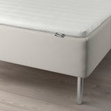 Ikea bed with mattress and stainless steel legs.