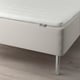 Close-up of a white IKEA mattress on bed frame with metal legs. Mattress cover has small dots for ventilation.