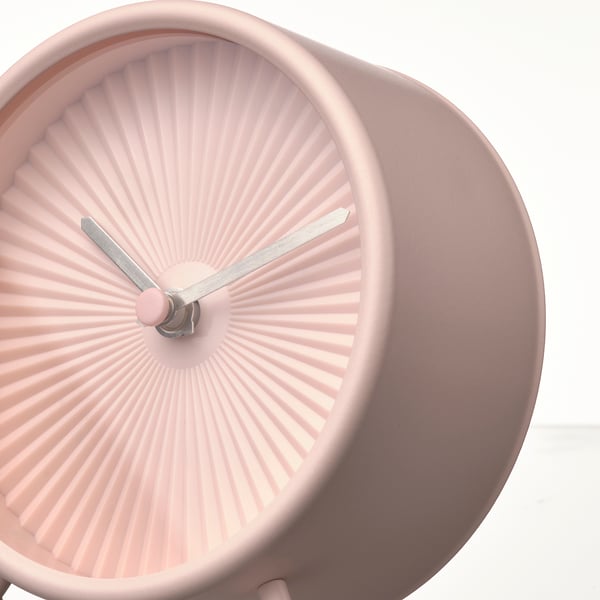 Blush pink modern clock with sleek design, two thin metal hands, and no ticking sound, displaying current time.