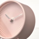 Blush pink modern clock with sleek design, two thin metal hands, and no ticking sound, displaying current time.