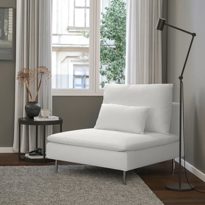 Modern minimalist living room with white SÖDERHAMN chair, black side table, floor lamp, and window view.