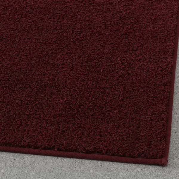 Thick, plush burgundy bath mat with latex backing, providing soft comfort and secure footing.