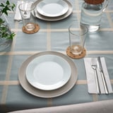 Table set with SOLABBORRE cork place mats, white plates, glasses, and cutlery. Cork coasters protect plates and table.