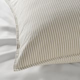 Striped pillow with gentle, high-quality fabric resting on another pillow, showcasing its soft, inviting texture.