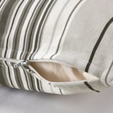 Close-up of striped cushion cover with open zipper showing inner lining.