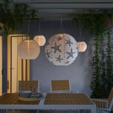Four solar-powered pendant lamps, one with starfish design, illuminate outdoor dining area. They hang from pergola, casting warm glow.