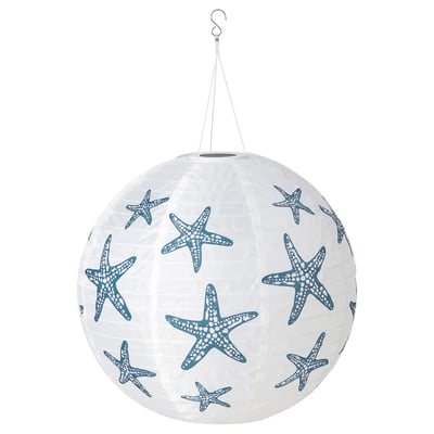 A SOLVINDEN white paper lantern with blue starfish prints, powered by solar energy. Its spherical and hangs from a hook, made from recycled materials.