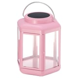 Pink solar-powered lantern with clear glass panels and metal handle. Modern design for indoor/outdoor use.