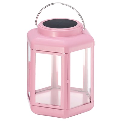 Pink solar-powered lantern with clear glass panels and metal handle. Modern design for indoor/outdoor use.