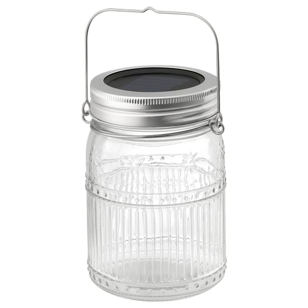 A SOLVINDEN solar jar lamp in clear glass with a silver lid and handle. Its designed for decorative, eco-friendly lighting both indoors and out.