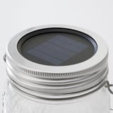 Solar-powered jar lamp with metal lid and glass body.