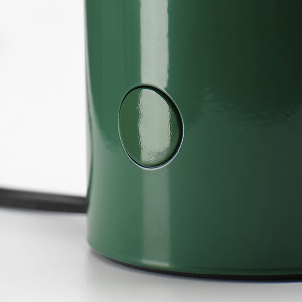 Green table lamp with sleek design, smooth surface, and circular power button.