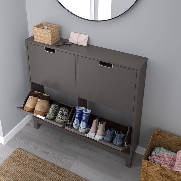 Shoe cabinet with 8 pairs, open for access, near wall, with mirror above.