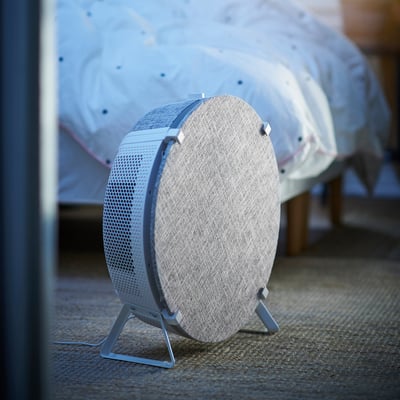 STARKVIND air purifier in light gray, compact round design with mesh surface and 3 legs.