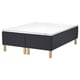 STAVANGER mattress base in dark gray with wooden legs supports a white and gray mattress featuring contouring comfort zones.