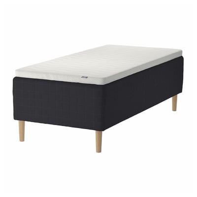 A STAVANGER bed in black with a white mattress. It has wooden legs and a quilted upholstered base.