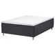 A STAVANGER bed in black with a white mattress. The bed has wooden legs and a padded base.