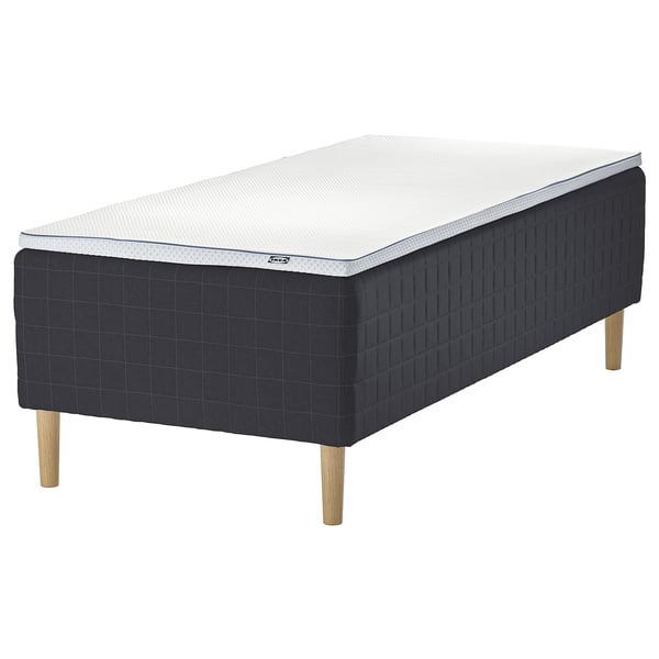 A gray IKEA STAVANGER bed with a white mattress featuring pocket springs for comfort.