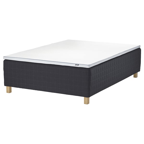 An IKEA STAVANGER bed in black with a white mattress on wooden legs.