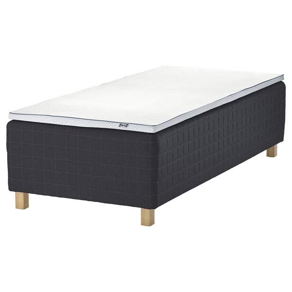 A black IKEA STAVANGER bed with a white mattress, supported by wooden legs, featuring a modern design.