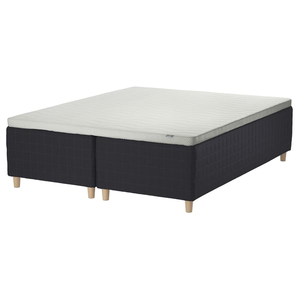 A STAVANGER bed in black with light grey mattress. It has wooden legs and a grid pattern.