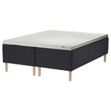 STAVANGER mattress base with wooden legs, black quilted fabric, rectangular shape.