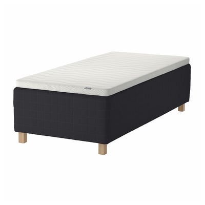 A black and white STAVANGER bed with a quilted pattern and wooden legs.