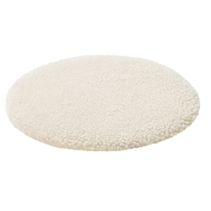 Circular white sheepskin rug, plush and soft.
