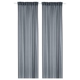 Two dark blue STENFRÖ sheer curtains hang straight, featuring heading tape, offering a soothing, relaxed vibe.