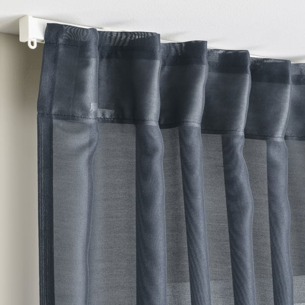 Gray sheer curtains hung with hooks, diffusing sunlight, offering privacy, and creating a calm atmosphere.