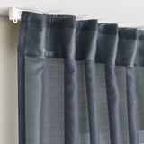 Gray sheer curtains hung with hooks, diffusing sunlight, offering privacy, and creating a calm atmosphere.